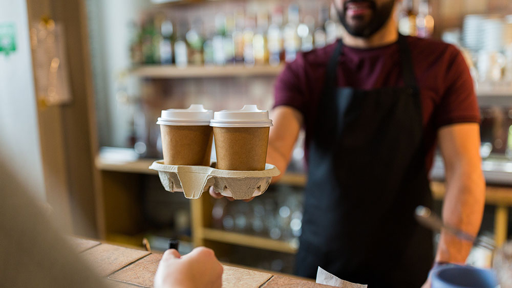 Bartender serving customer at coffee shop