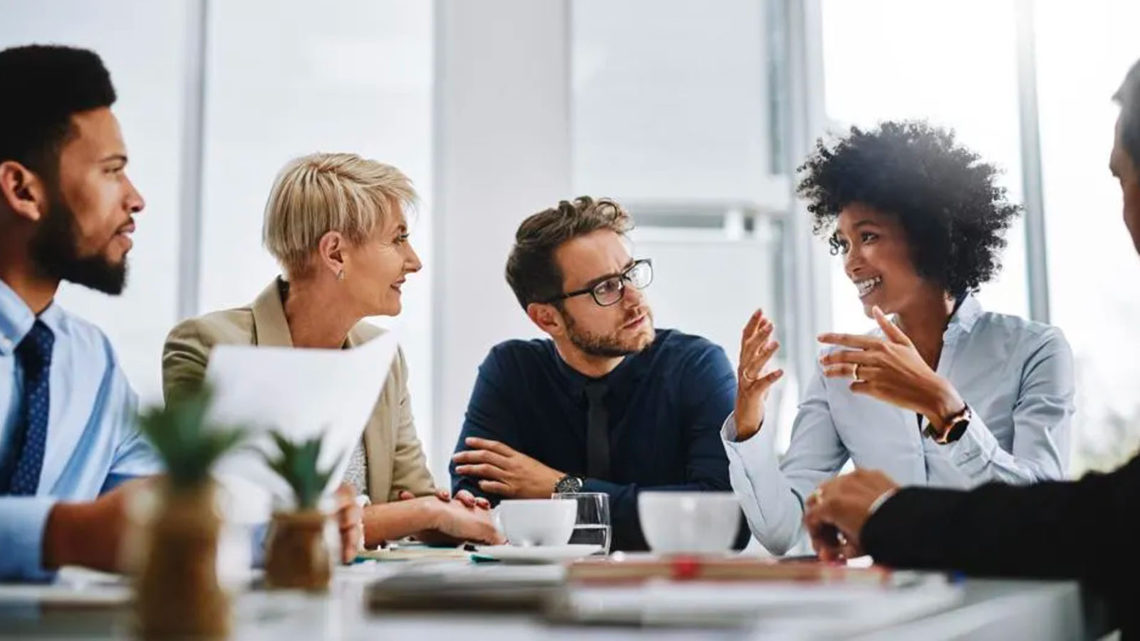 Happy diverse office workers team laughing together at group meeting