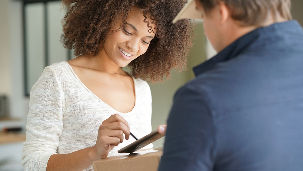 Woman receiving package from delivery man